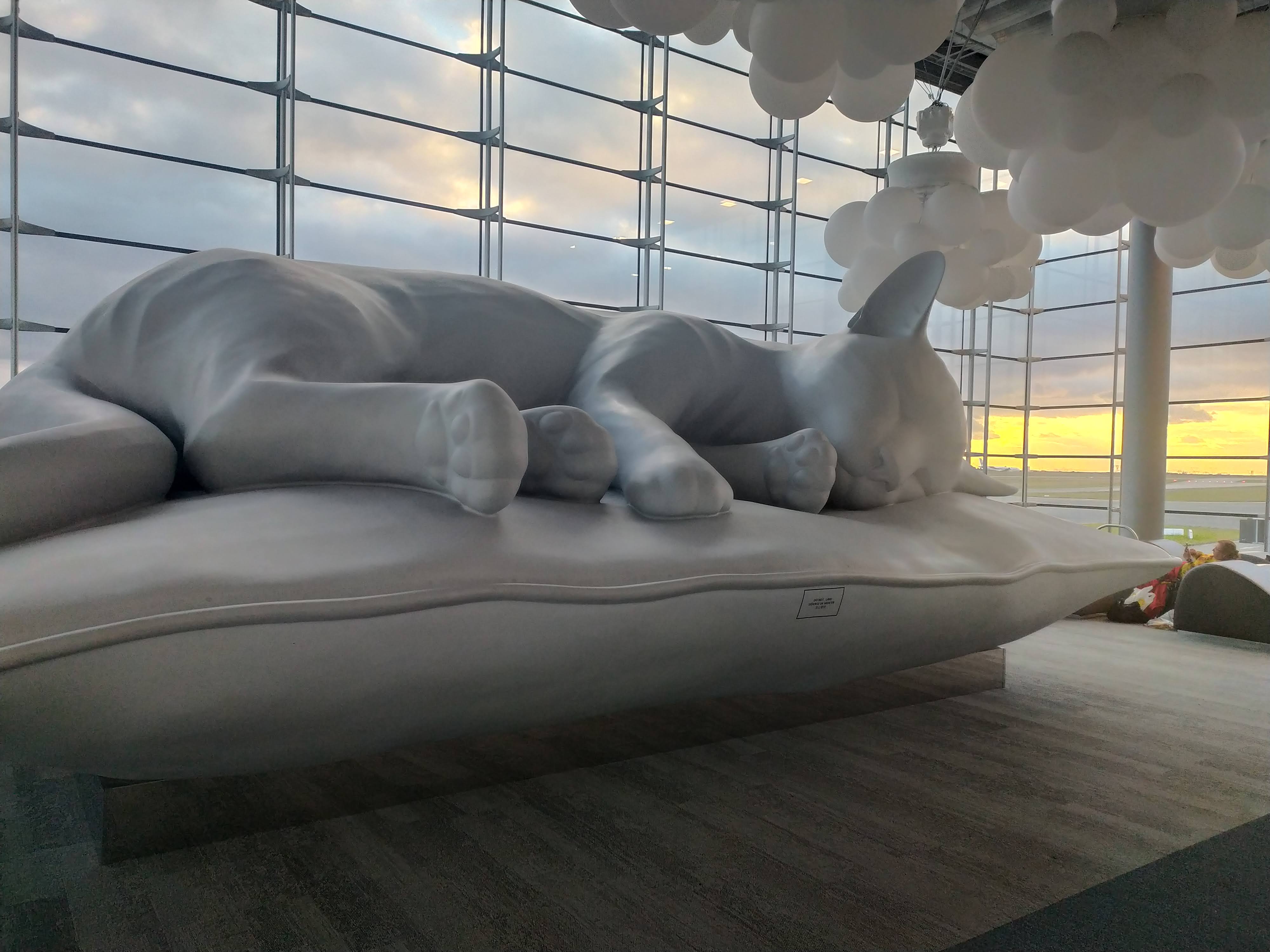 Green tent pitched on a rocky mountain slope overlooking a valley at sunset